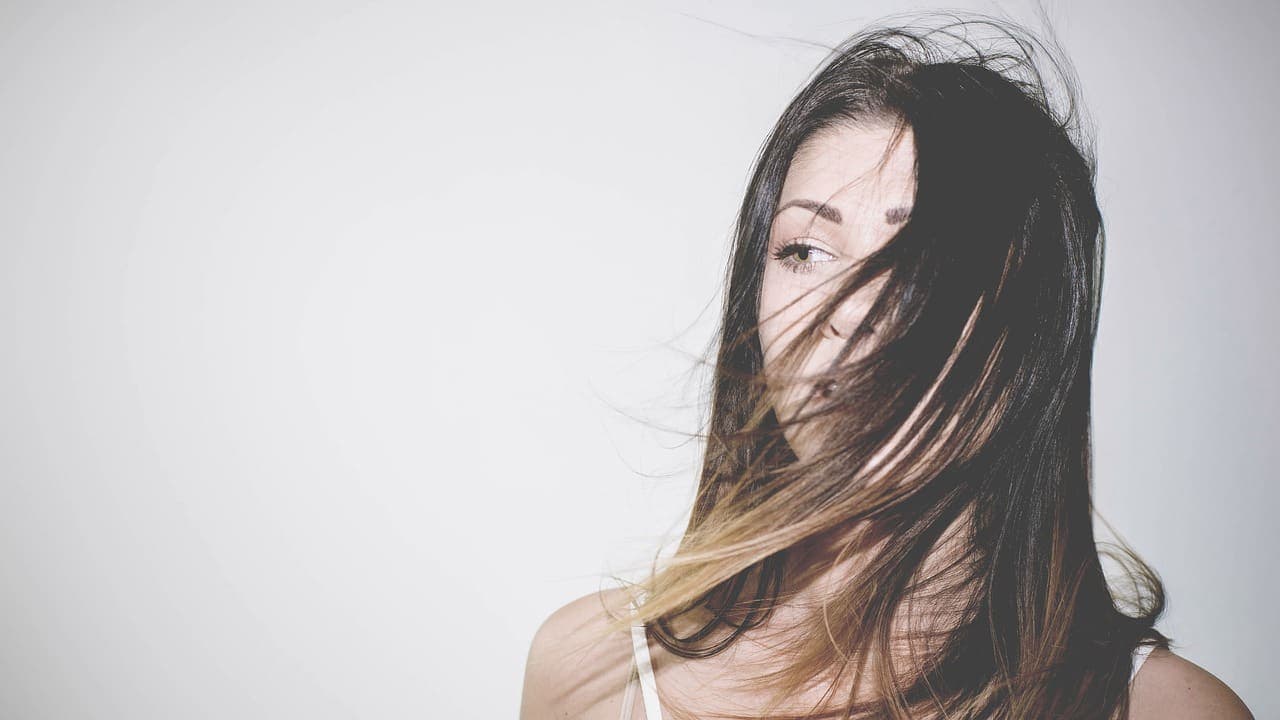 Dark glossy hair moving across the face